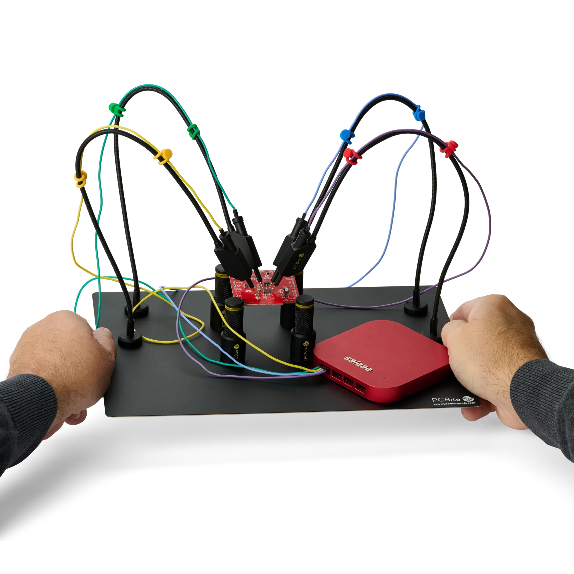 Hands lifting a whole PCBite setup with probes on a PCB and a Saleae logic analyzer, every needle staying in contact.