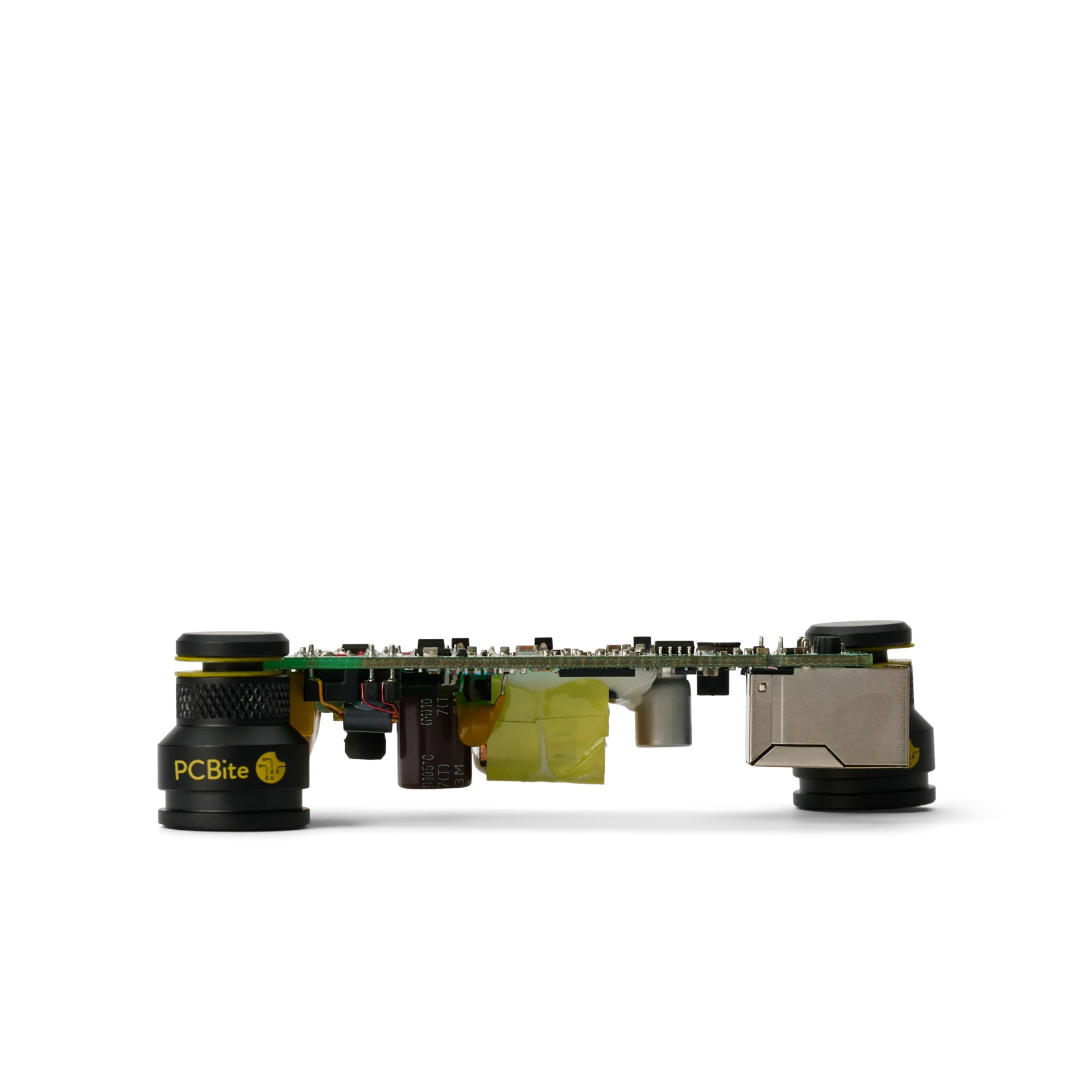 PCB held close to the surface by two low profile PCBite holders, seen from the side with tall parts fitting underneath.