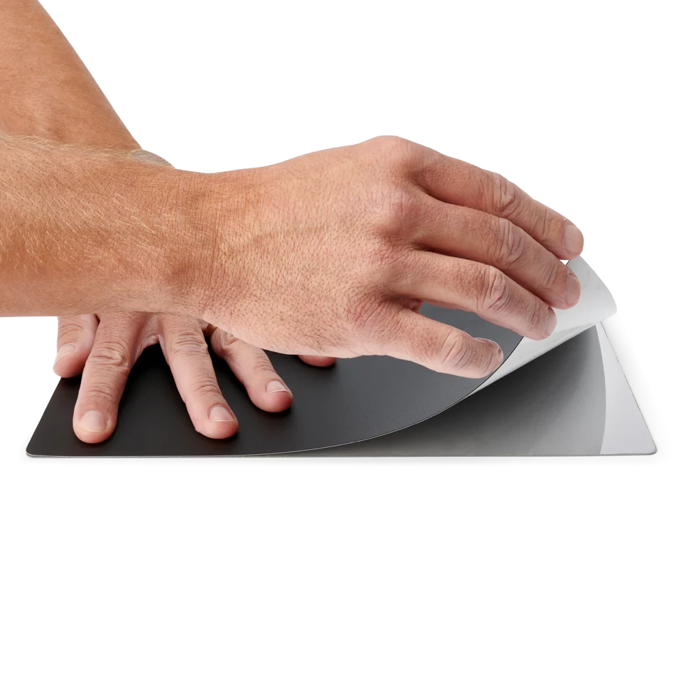 Hands applying the A4 sized insulation cover on the large baseplate (PCBITE-4017)