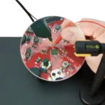 Hand measuring on small PCB components visible through the AR coated 3x magnifying lens (PCBITE-4020)