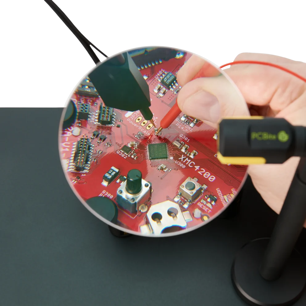 Hand measuring on small PCB components visible through the AR coated 3x magnifying lens (PCBITE-4020)