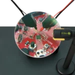 Two probes are placed on PCB under test visible through the magnifying lens of magnifier (PCBITE-4020)