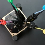 Four handsfree SQ10 probes with spring-loaded tips probing IC on PCB with cable holders (PCBITE-6005)