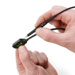 Hand showing how to mount SQ200 200 MHz oscilloscope probe in the SQ probe holder for handsfree measurements (PCBITE-6016)