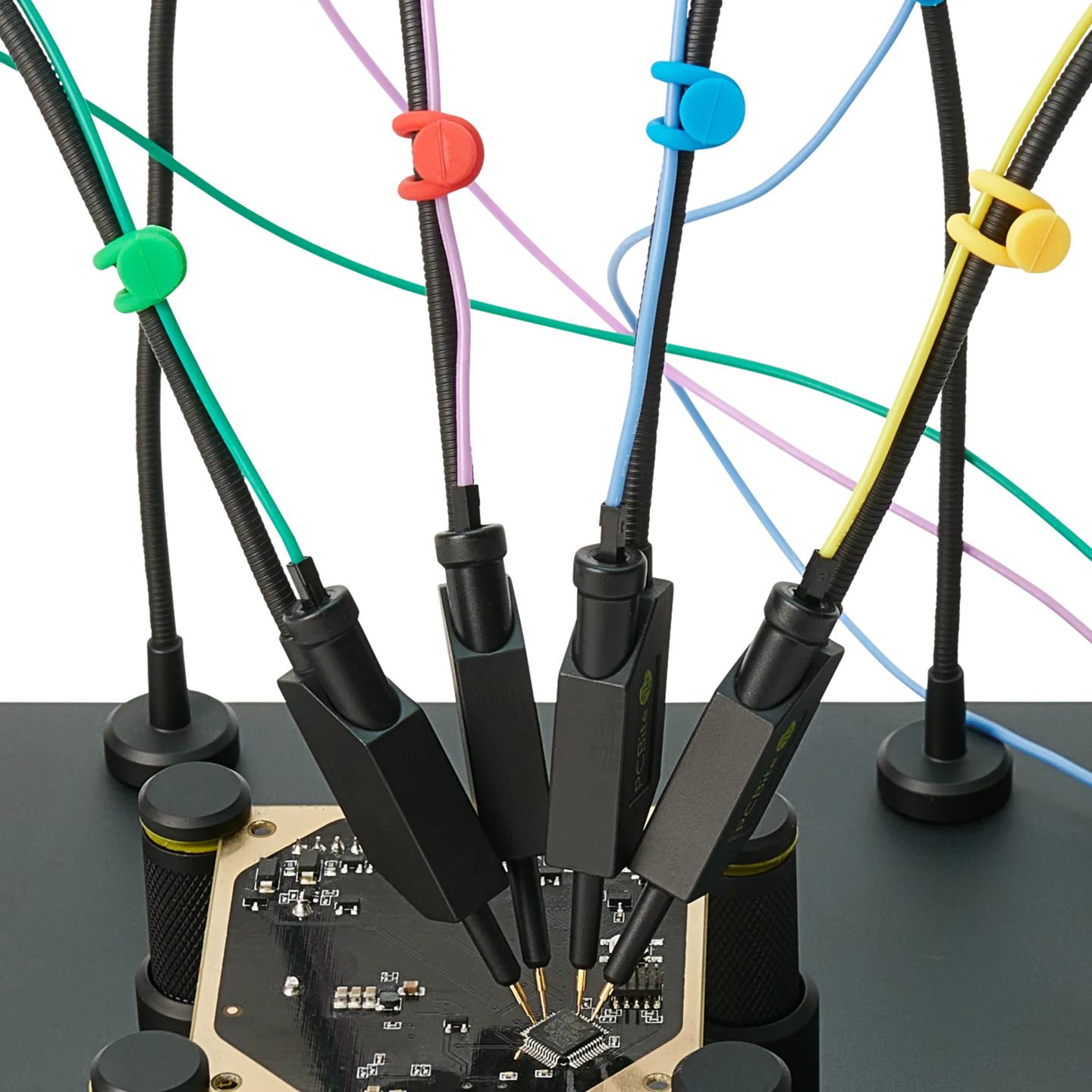Four handsfree SQ10 probes with spring-loaded tips probing PCB signals with color-coded cable holders (PCBITE-6019)