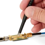 Hand measuring on PCB using SQG15 1.5 GHz probe with mounted dual ground spring (PCBITE-7009)