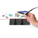 Hand soldering wire held by two magnetic spring-loaded PCB holders on the small insulated baseplate (PCBITE-7025)