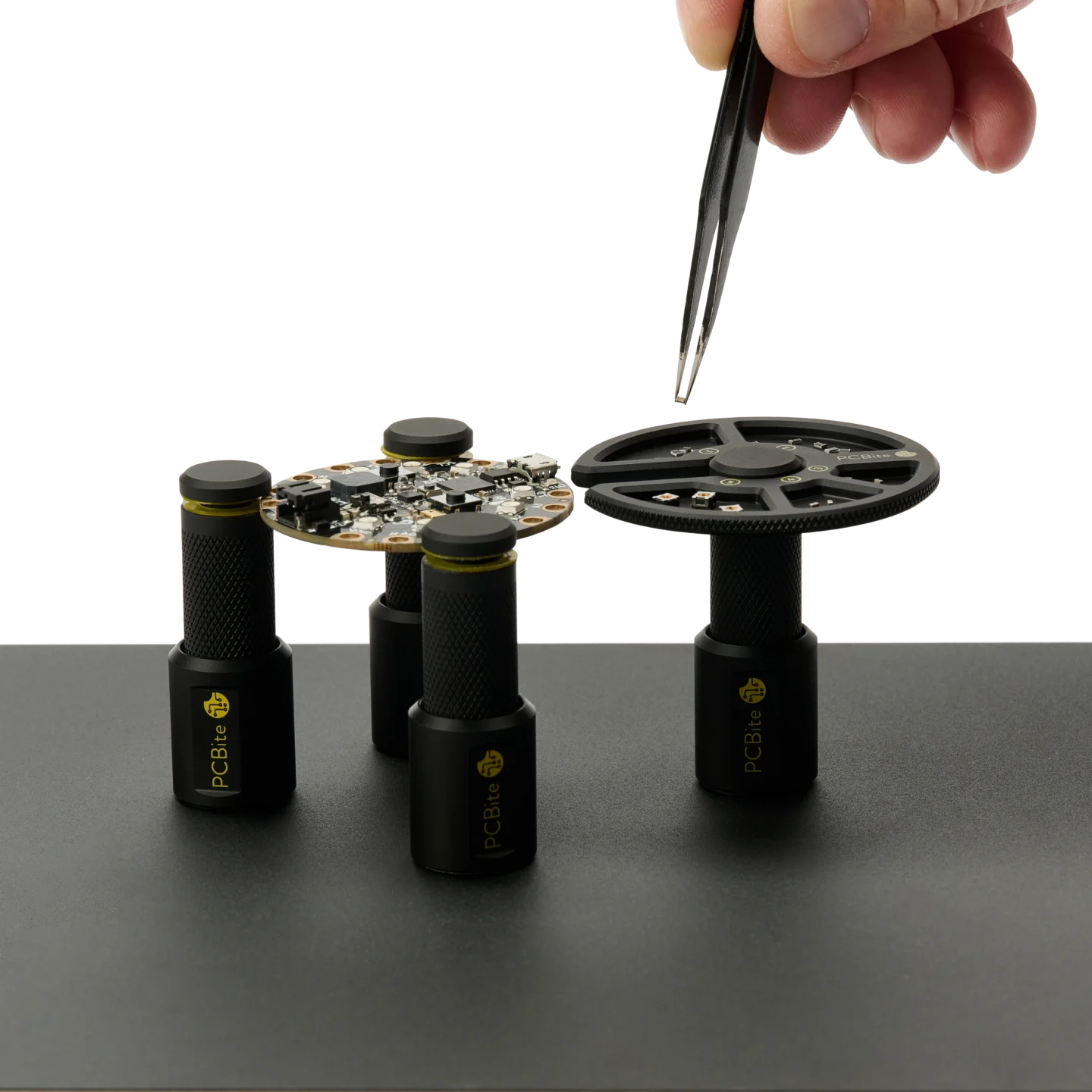 Hand picking components with tweezer from the component tray held by a PCB holder (PCBITE-7029)