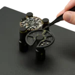 Hand picking components with tweezer from component tray and placing on PCB for soldering (PCBITE-7029)