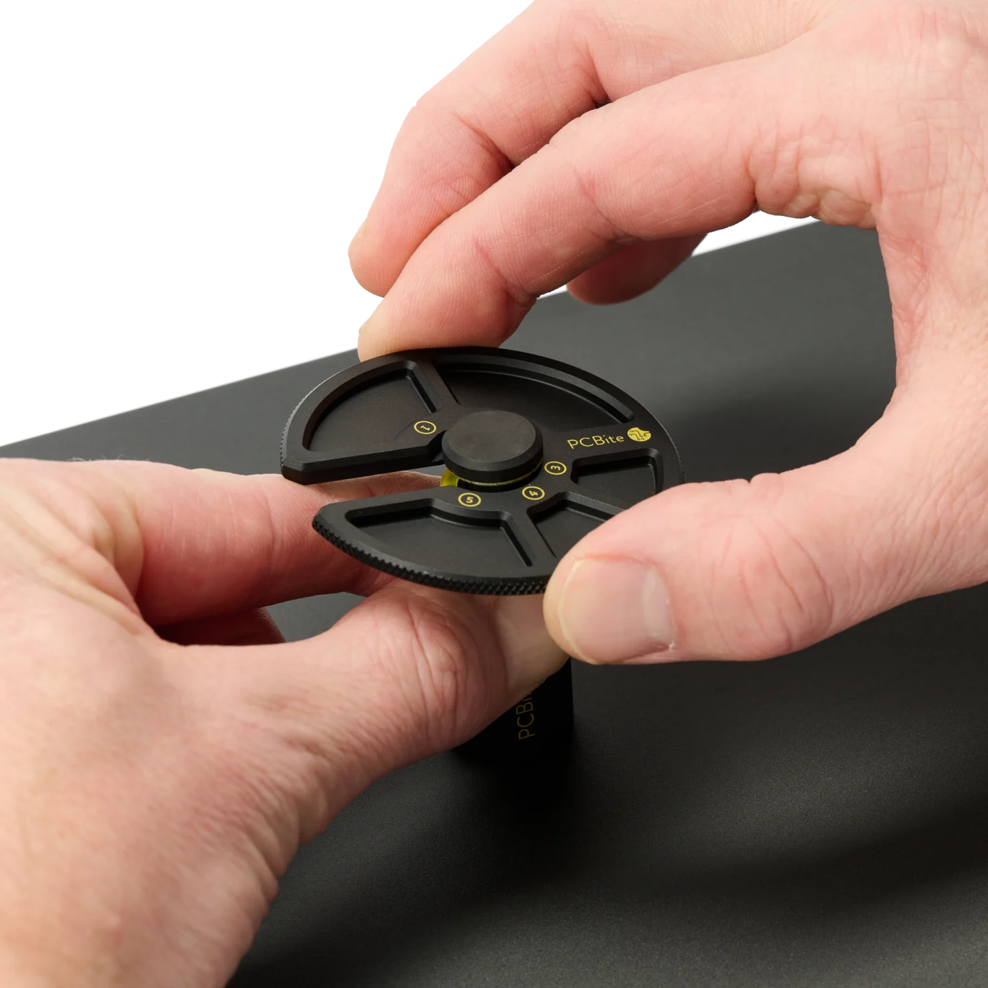 Hand opening a PCB holder and another sliding the component tray into position (PCBITE-7029)