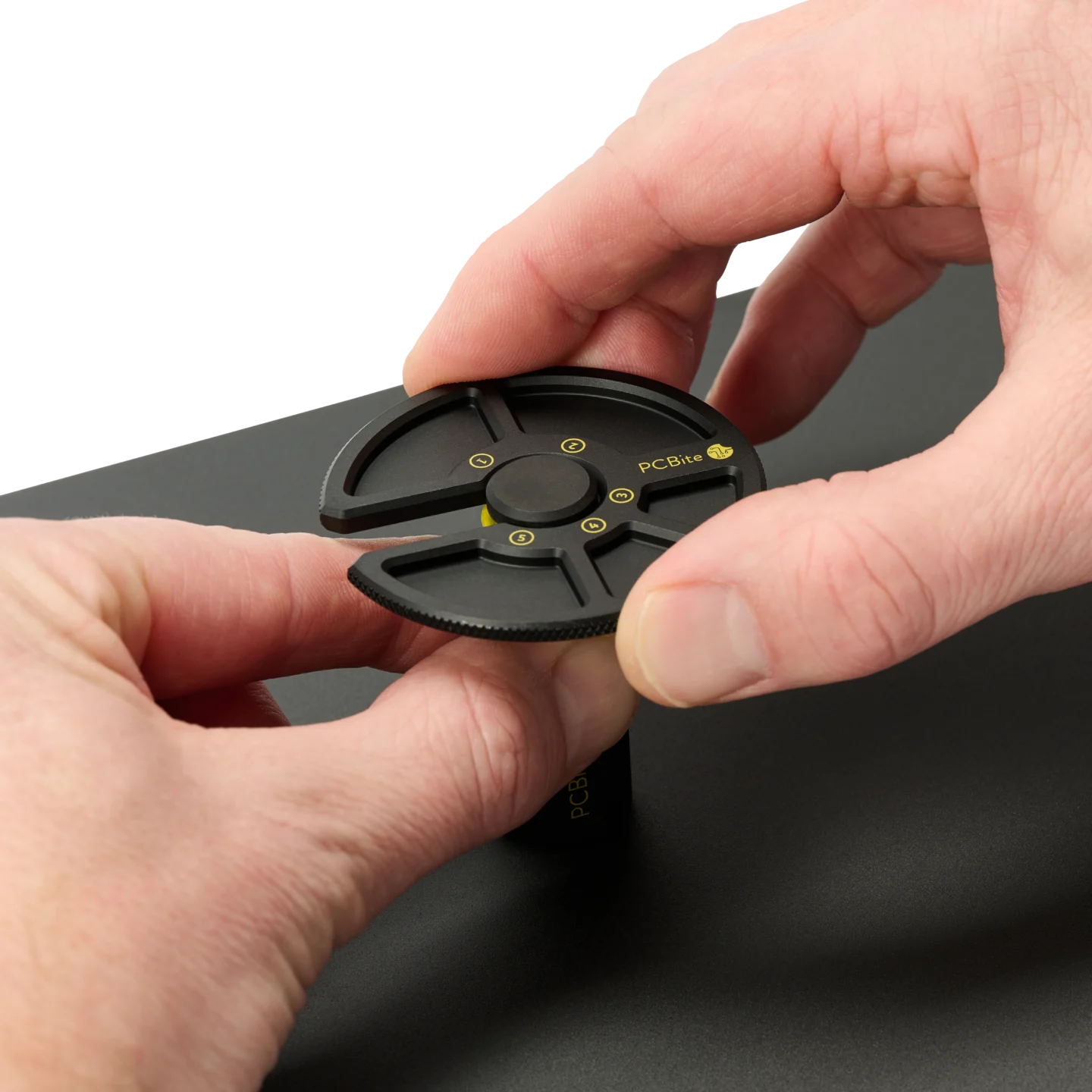 Hand closing a PCB holder and another holding the component tray in position (PCBITE-7029)
