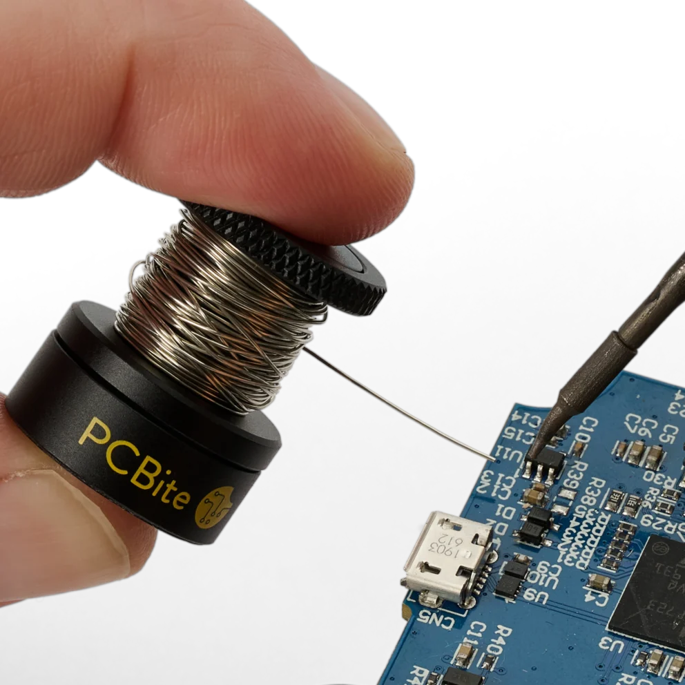 Closeup of hand holding the small wire stand when soldering on PCB (PCBITE-7030)
