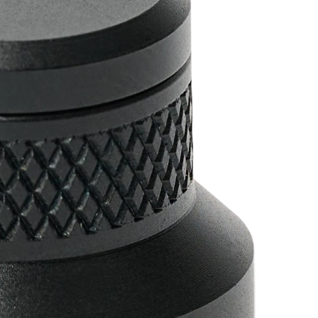 Knurled black anodized aluminum of a PCBite holder in close-up, machined and finished to last for years in the lab.