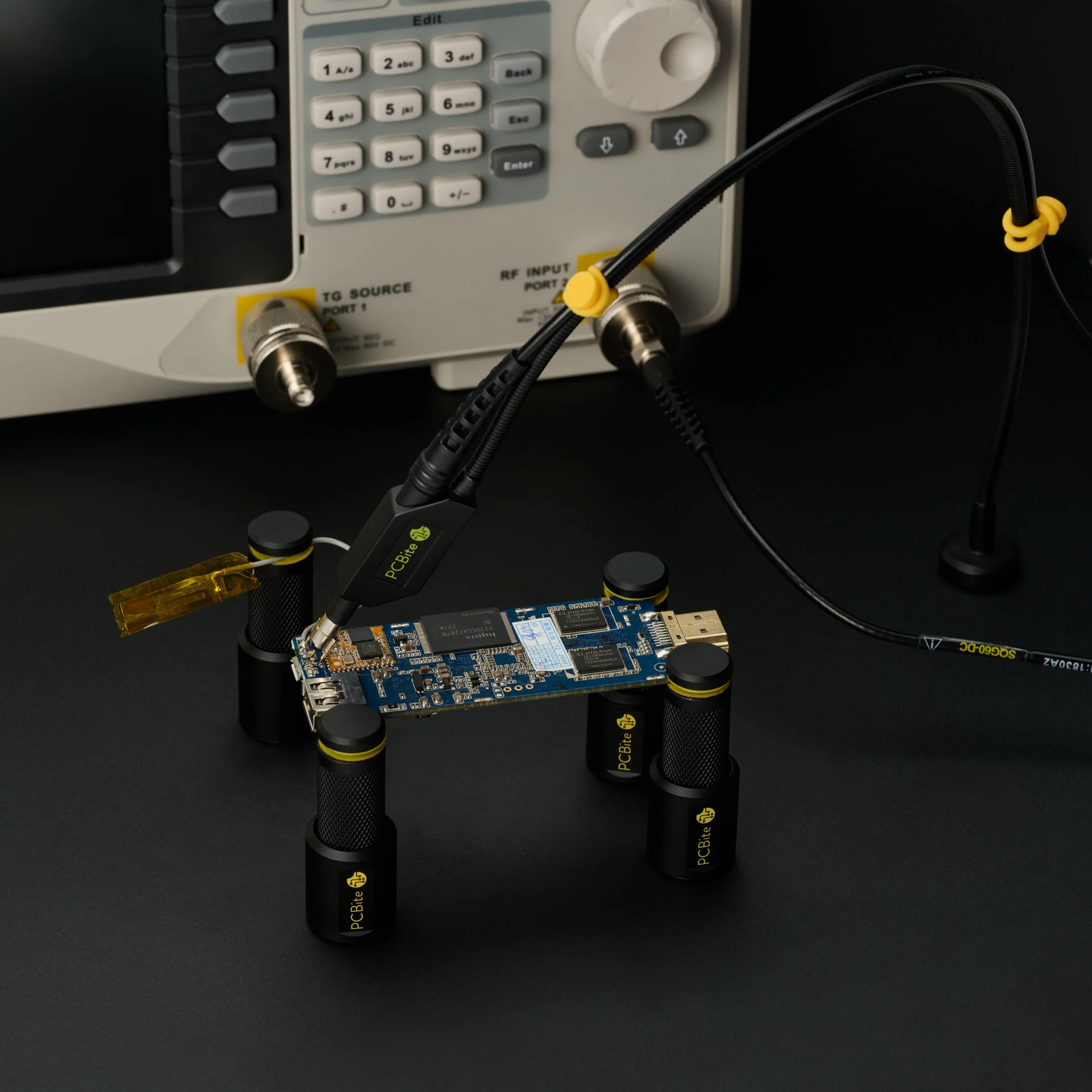 SQG probe on a PCB in PCBite holders, connected to an analyzer input, with the model and probe ID printed on its cable.