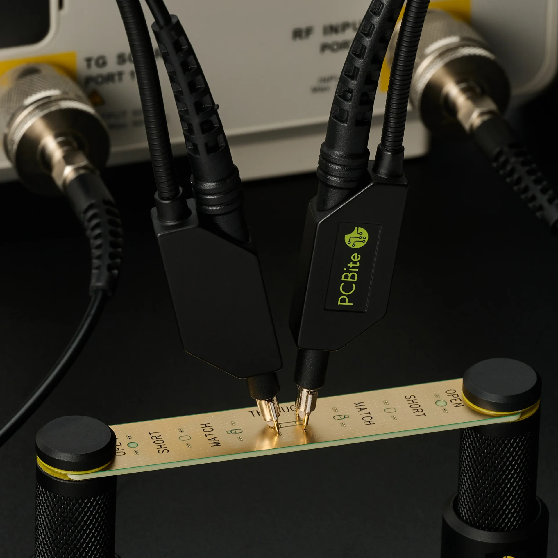 Two SQG probes resting handsfree on the through line of a calibration board, wired to the analyzer ports for repeatable results.