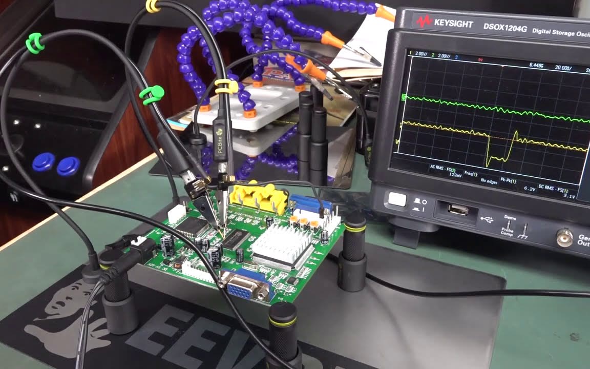 PCBite handsfree probes on a circuit board next to an oscilloscope on the EEVblog bench.