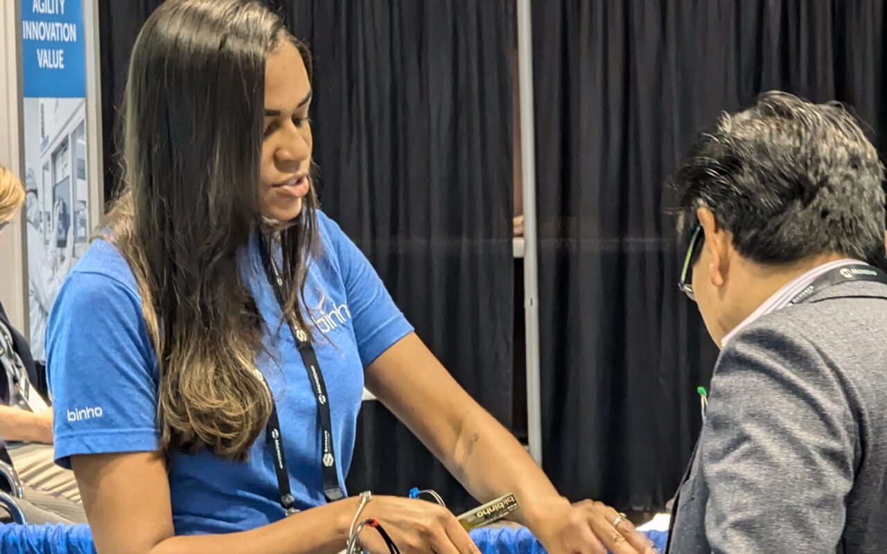 A Binho team member shows PCBite to a visitor at Sensors Converge 2024 in Santa Clara.