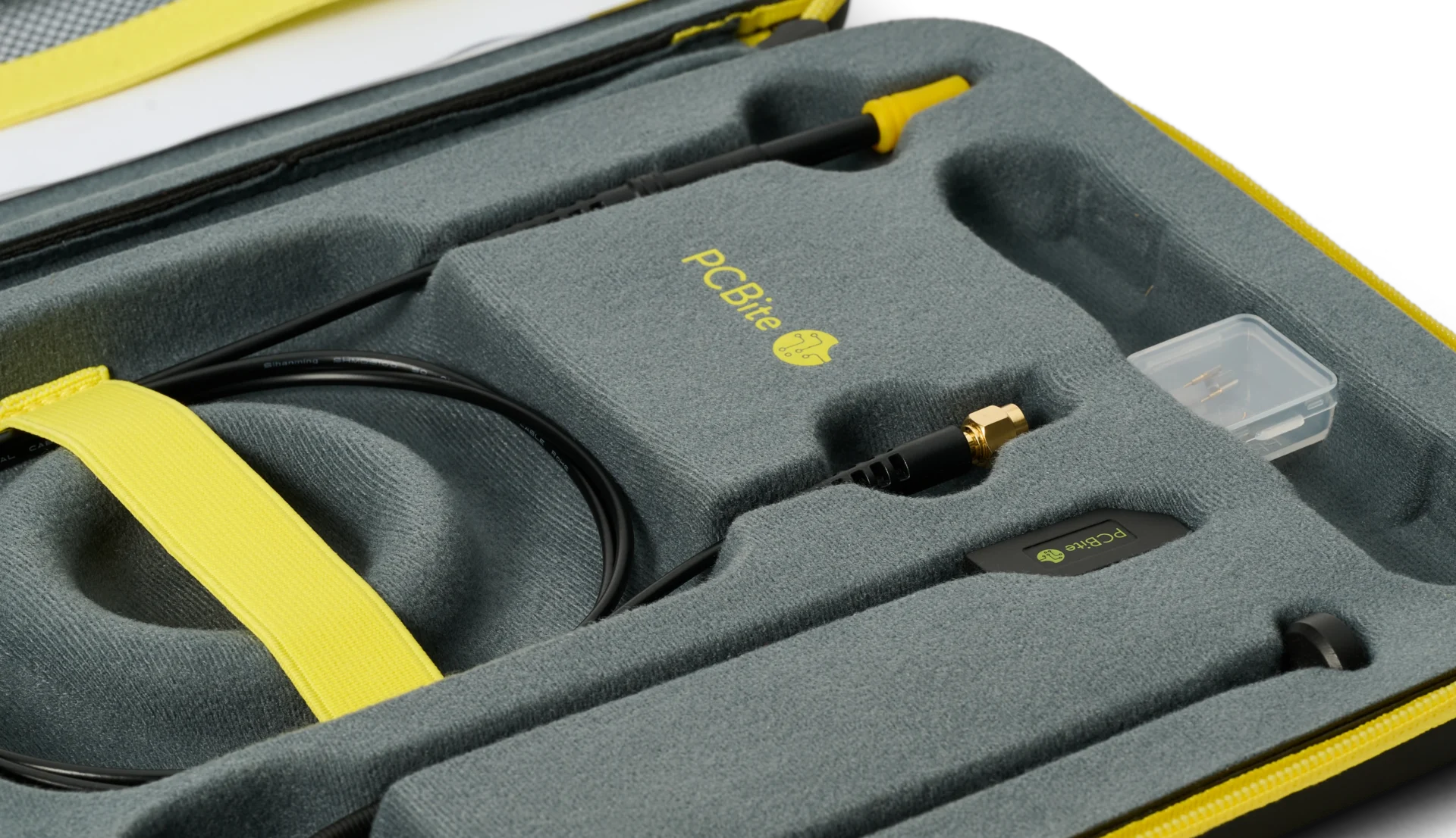 Opened PCBite case with an SQG probe, its SMA cable and accessories, each in a fitted foam compartment.